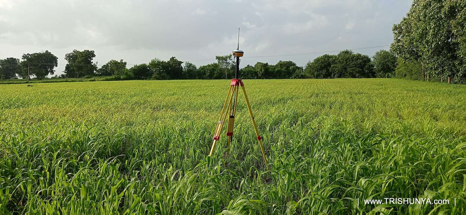 DGPS device being used for topographic survey work in an open farm with green plants